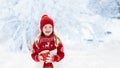 Child drinking chocolate on Christmas in snow