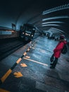 A child in a red jacket waits for a train at a metro station