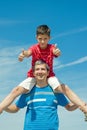 Child in a red shirt sitting on his father