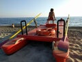 Child on a red shoe, in a Versilia beach, observing the tranquility of the sea on the horizon