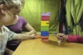 Child removing a piece of the wooden tower