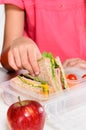 Child removing wholemeal sandwich out of lunchbox Royalty Free Stock Photo