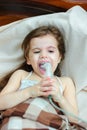 Child with respiratory illness making inhalation with inhaler.