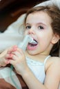 Child with respiratory illness making inhalation with inhaler.