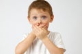 Child holds back the emotion of fear by covering his mouth with his hands Royalty Free Stock Photo