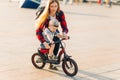 Child rides a bike while his mother walks beside him. Happy mother teaches her son to ride a bike in the park Royalty Free Stock Photo