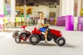 A child rides a toy pedal car at a children's play center Royalty Free Stock Photo