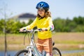 Child riding bicycle. Little kid boy in helmet on bicycle along bikeway. Happy cute little boy riding bicycle in summer