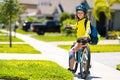 Child riding bicycle. Little kid boy in helmet on bicycle along bikeway. Happy cute little boy riding bicycle in summer