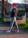 Child riding on kickscooter alone. Blonde cute girl on scooter on spring city park street background. Active lifestyle