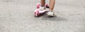 Child riding scooter. Happy little kid girl playing pink kick board on road in park outdoors on summer day, Active children games Royalty Free Stock Photo