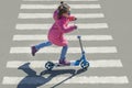 Child riding scooter. Kid on colorful kick board. Active outdoor fun for kids. Sports for preschool children. Little happy girl Royalty Free Stock Photo