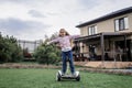 Child riding on self-balancing hover board on the backyard of cottage, outdoor kids activity