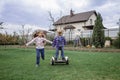 Child riding on self-balancing hover board on the backyard of cottage, outdoor kids activity
