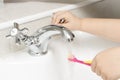 Child Rinsing Toothbrush in Running Bathroom Sink Water Royalty Free Stock Photo