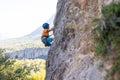 Child rock climber. The boy climbs the rock. The child is engaged in rock climbing on natural terrain. Sports kid spends time Royalty Free Stock Photo