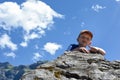 A child rock climbing during an outdoor exercise adventure with mountain scenery