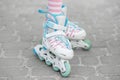 The child is rollerblading in the yard. Girl in pink tights. Childhood and hobby concept Royalty Free Stock Photo