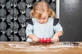 Child Rolling Gingerbread Dough with Festive Rolling Pin on Kitchen Table Royalty Free Stock Photo