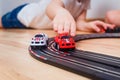The child rolls small cars on a toy car track