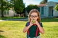 Child with rucksacks in the school park. Pupils with backpacks outdoors. Schoolboy eating apple. Royalty Free Stock Photo