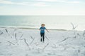 Child run on the seagulls on the beach, summer time. Cute little boy chasing birds near sea on summer day. Royalty Free Stock Photo