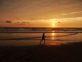 Child running across beach at sunset Royalty Free Stock Photo