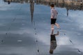 Child running playfully on the wet ground of \