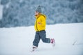 Child running on snow in winter. Kids playing and jumping in snowy forest. A kid runs through the snow. Royalty Free Stock Photo
