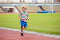 Child running in stadium. Kids run. Healthy sport