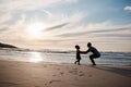 Child is running to father, beach and silhouette, family with games and love, travel and freedom together outdoor