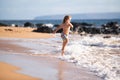 Child running through water close to shore along the sea beach. A boy runs along the sea coast. Rest of children on Royalty Free Stock Photo