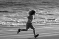 Child running through water close to shore along the sea beach. A boy runs along the sea coast. Rest of children on Royalty Free Stock Photo