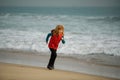 Child running through water close to shore along the sea beach. A boy runs along the sea coast. Child runner jogger Royalty Free Stock Photo