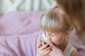 Child with runny nose. Mother helping to blow kid`s nose with paper tissue. Seasonal sickness Royalty Free Stock Photo