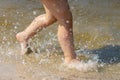 A child runs along the river bank splashing water with his feet Royalty Free Stock Photo