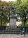 Child runs past statue in Place des Vosges, Paris