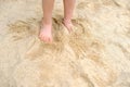 Child`s bare feet in the sand, boy plays in the summer with sand on the playground, in the sandbox, the concept of building sand Royalty Free Stock Photo