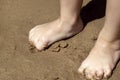 The child`s bare feet on the yellow sand Royalty Free Stock Photo