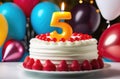 child\'s birthday party with balloons, cake with berries and lighted candle in shape of number five Royalty Free Stock Photo