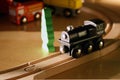 Child's black wooden toy train on wood tracks