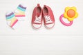 Child`s booties, teether and socks on white table, flat lay. Space for text Royalty Free Stock Photo