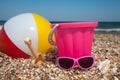 Child's bucket, ball and other toys on tropical beach against blue sky Royalty Free Stock Photo