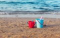 Child`s bucket, spade and other toys on empty beach Royalty Free Stock Photo