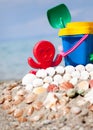 Child's bucket, spade and other toys on tropical beach against b