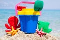 Child's bucket, spade and other toys on tropical beach against b Royalty Free Stock Photo
