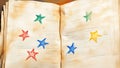 Child's crayon drawing of colorful stars adorns aged notebook pages