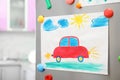 Child`s drawing and magnets on refrigerator door Royalty Free Stock Photo