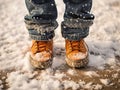 a child\'s feet in light brown winter boots on the snow