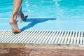 child`s feet step to the swimming pool. Child is ready to jump in the water.